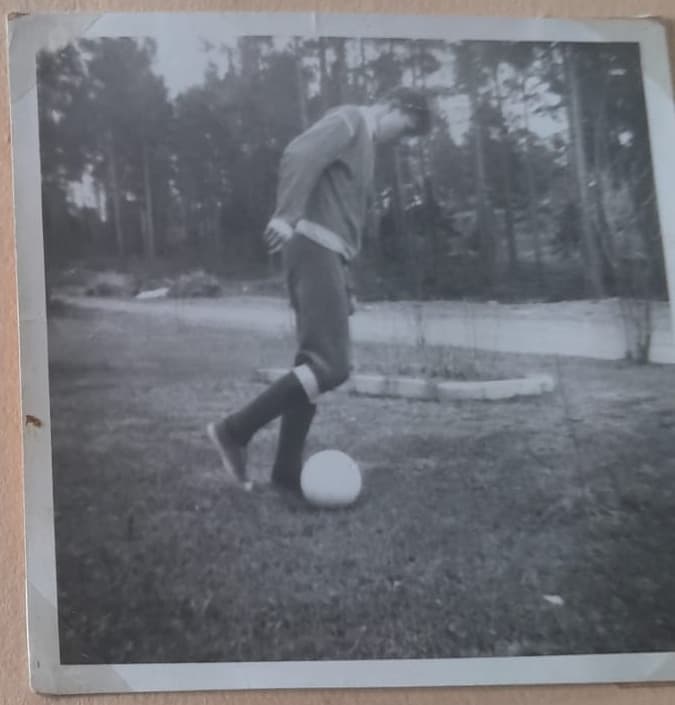 Original albumfoto av en ung person med foten på bollen
