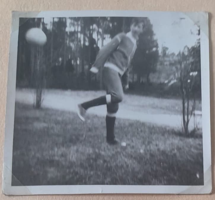 Original albumfoto av en ung person som sparkar en boll