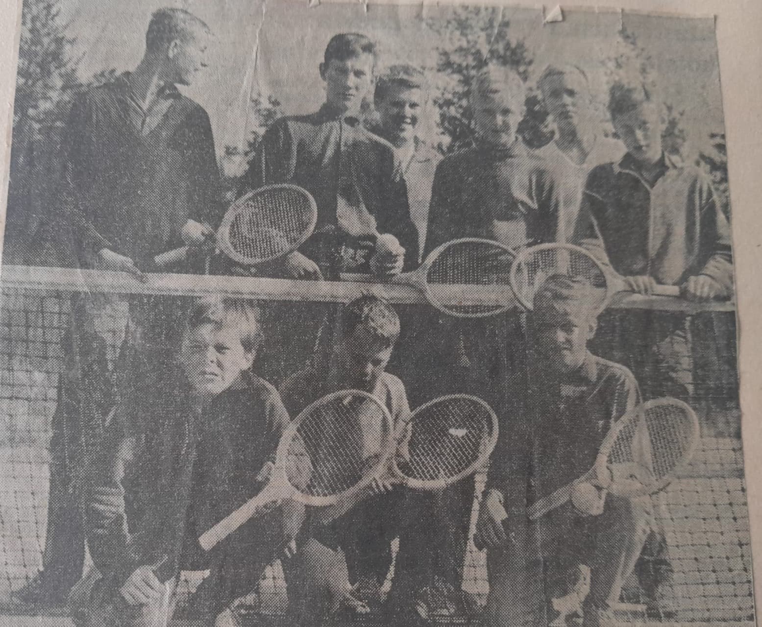 Original tidningsbild med unga tennisspelare bakom nätet
