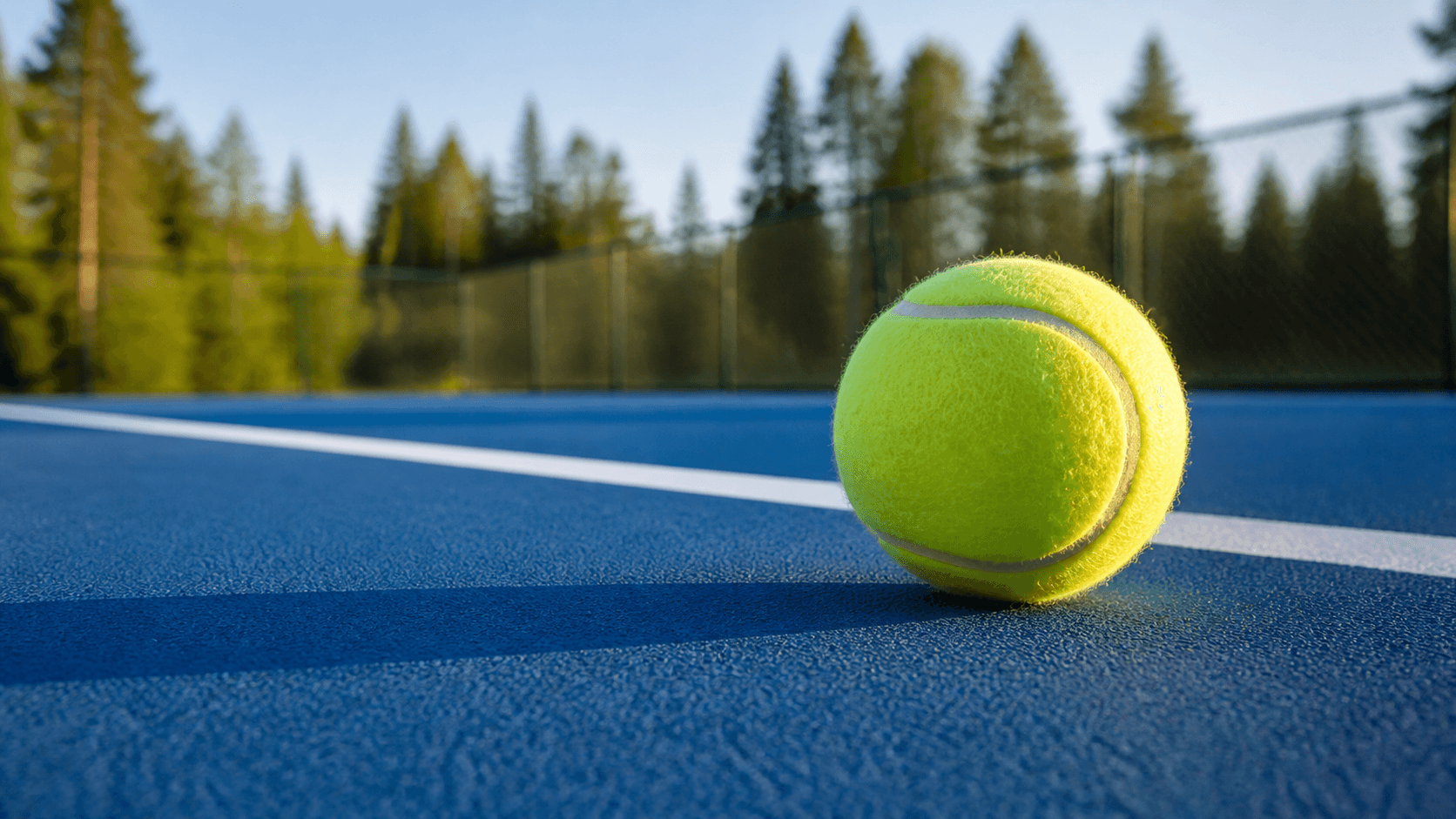 Illustration av en tennisboll på en blå hardcourtbana